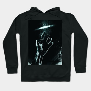 Digital collage and special processing. Person looking on his hand. Bizarre, dark. Grayscale and aquamarine. High contrast. Hoodie